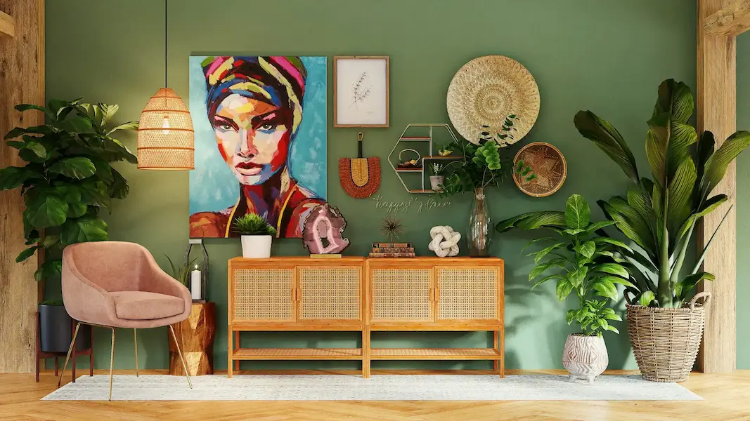 Un salon décoré avec un mur vert, un grand tableau coloré représentant une femme, un meuble en rotin, des plantes vertes, un fauteuil rose, et divers objets de décoration murale.